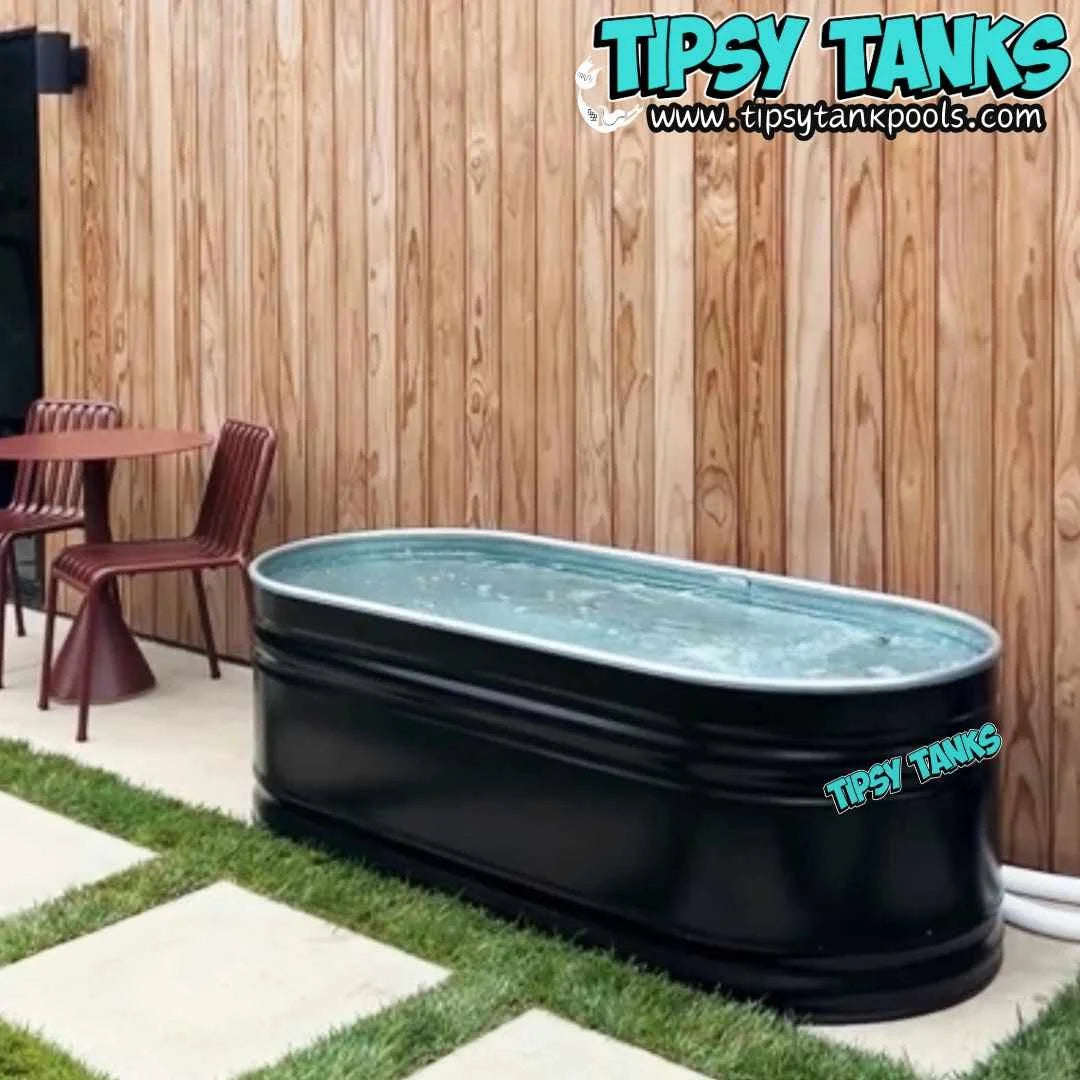 Black Tipsy Tanks pool in an outdoor setting with a wooden wall and chairs.