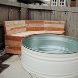 Wooden bench and metal water tank in a backyard setting by Tipsy Tank Pools